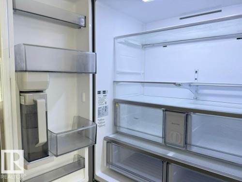 Integrated refrigeration unit with adjustable shelving, multiple crisper drawers, door storage bins, and a built-in water dispenser - 5034 Rivers Edge Way, Edmonton, AB 