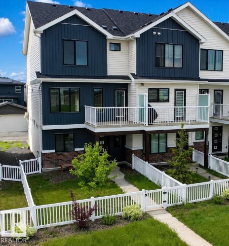 Modern multi-level exterior featuring dark blue vertical siding and light-colored horizontal siding - 5034 Rivers Edge Way, Edmonton, AB 