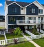 Modern multi-level exterior featuring dark blue vertical siding and light-colored horizontal siding - 5034 Rivers Edge Way, Edmonton, AB 