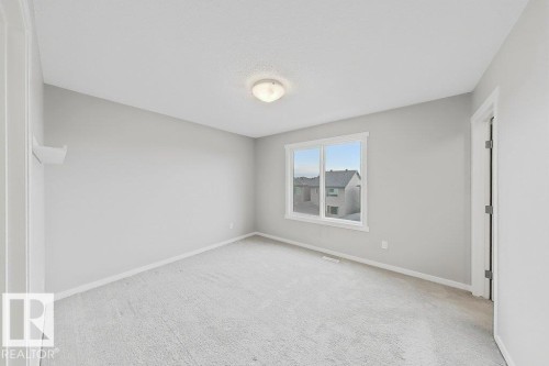 Room featuring light gray wall paint, white trim, and a textured ceiling - 5034 Rivers Edge Way, Edmonton, AB 