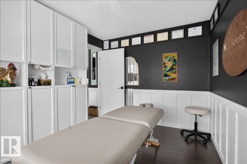 Contemporary room featuring dark wood-finish flooring and white wainscoting - 13 Baie Madelene, Beaumont, AB 