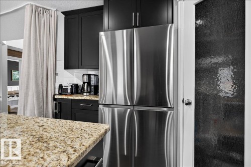 Stainless steel refrigerator integrated with black cabinetry - 13 Baie Madelene, Beaumont, AB 