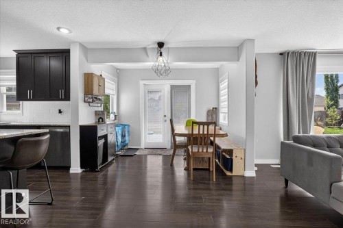 Open-concept living area with dark wood-finish flooring - 13 Baie Madelene, Beaumont, AB 