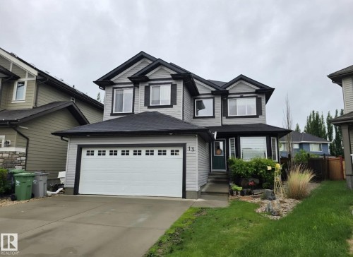 Two-story residence featuring gray siding with dark trim accents - 13 Baie Madelene, Beaumont, AB 