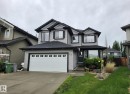 Two-story residence featuring gray siding with dark trim accents - 13 Baie Madelene, Beaumont, AB 