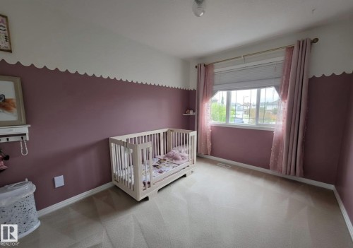 Bright interior space featuring a large window with horizontal blinds and a gold-tone curtain rod - 13 Baie Madelene, Beaumont, AB 