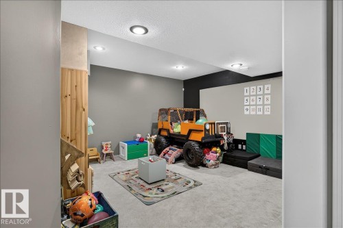 Carpeted room featuring recessed lighting and a wood-paneled wall accent - 13 Baie Madelene, Beaumont, AB 
