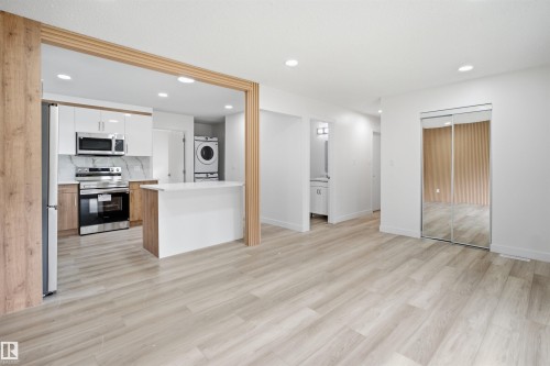 Open-concept living space featuring wood-finish flooring and recessed lighting - 3548 20 Ave, Edmonton, AB 