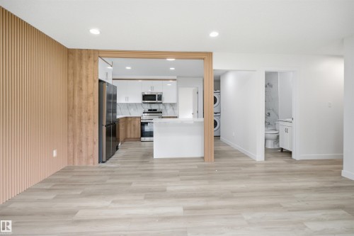 Modern kitchen featuring stainless steel appliances, white cabinetry, and a peninsula with a white countertop - 3548 20 Ave, Edmonton, AB 