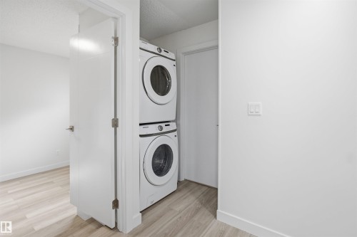 Full-size stacked washer and dryer in a dedicated utility area - 3548 20 Ave, Edmonton, AB 