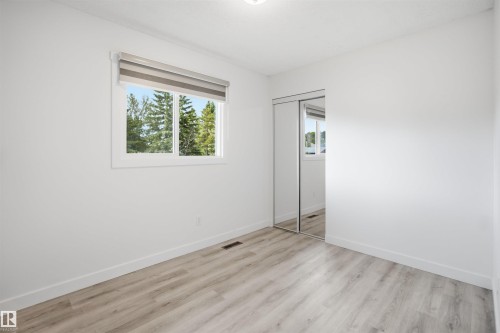 Room featuring light wood-finish flooring, white walls, and a window with a roller shade - 3548 20 Ave, Edmonton, AB 