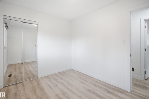 Light-toned wood-finish flooring complements white walls and trim - 3548 20 Ave, Edmonton, AB 