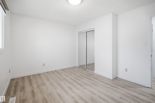 Room featuring wood-finish flooring, white baseboards, and a contemporary ceiling light fixture - 3548 20 Ave, Edmonton, AB 
