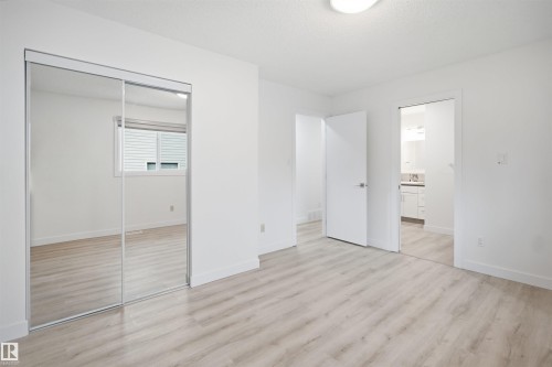 Light wood-finish flooring complements the bright white walls and trim - 3548 20 Ave, Edmonton, AB 