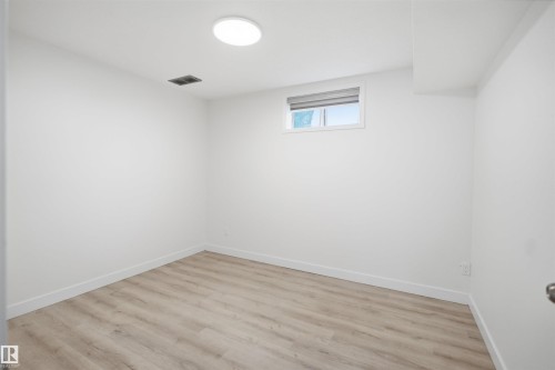 Room featuring light wood-finish flooring, white painted walls, and a recessed ceiling light - 3548 20 Ave, Edmonton, AB 