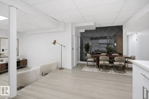 Open-concept living space featuring light wood-finish flooring, white walls, and a recessed ceiling - 3548 20 Ave, Edmonton, AB 