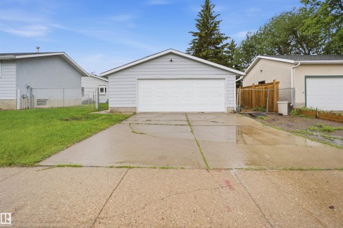 Two-car detached garage with light gray siding and a white overhead door - 3548 20 Ave, Edmonton, AB 