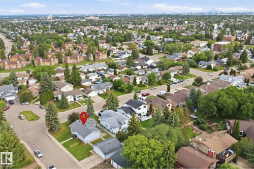 Aerial perspective showcasing a residential neighborhood with a single-family home featuring a light-colored exterior and an attached garage - 3548 20 Ave, Edmonton, AB 
