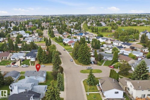 Aerial perspective showcasing a residential neighborhood with numerous detached homes, mature trees, and paved streets - 3548 20 Ave, Edmonton, AB 