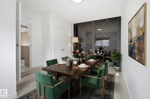 Dining area featuring light wood-finish flooring, white walls, and a prominent decorative mirrored wall with geometric accents - 3548 20 Ave, Edmonton, AB 