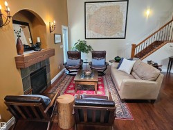 Inviting living space featuring a floor-to-ceiling fireplace with a wood-finish mantel and slate-look tile surround - 