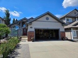 Modern exterior featuring light-colored siding, contrasting gray trim, and brick accents - 