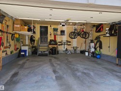 Spacious garage featuring a concrete floor, overhead storage racks, and wall-mounted organization systems - 