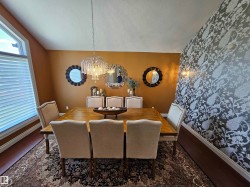 Formal dining area featuring a wood-finish dining table and upholstered chairs - 