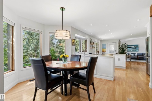 Bay window dining area with a drum pendant light fixture, light wood-finish flooring, recessed lighting, and white kitchen cabinetry - 624 Butchart Wynd, Edmonton, AB 