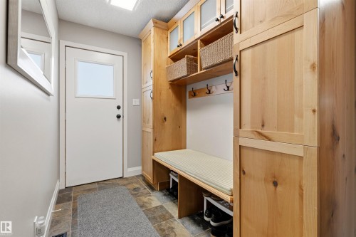 Entryway featuring a built-in wood storage system with bench seating - 624 Butchart Wynd, Edmonton, AB 