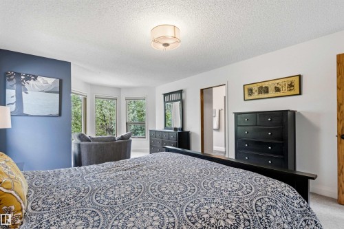 Spacious interior featuring a bay window, recessed wall section with accent color, and an overhead drum light fixture - 624 Butchart Wynd, Edmonton, AB 