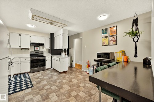 Kitchen featuring white cabinetry, a white tile backsplash, and stainless steel appliances - 24 Addison Crescent, St. Albert, AB 