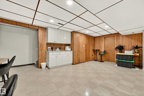 Finished room featuring wood-paneled walls and a grid drop ceiling with recessed lighting - 24 Addison Crescent, St. Albert, AB 