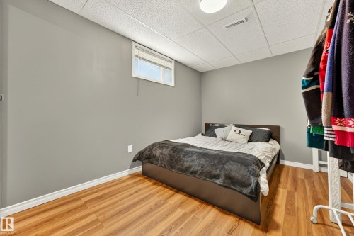 Room featuring wood-finish flooring, light grey walls, and a white drop ceiling - 24 Addison Crescent, St. Albert, AB 