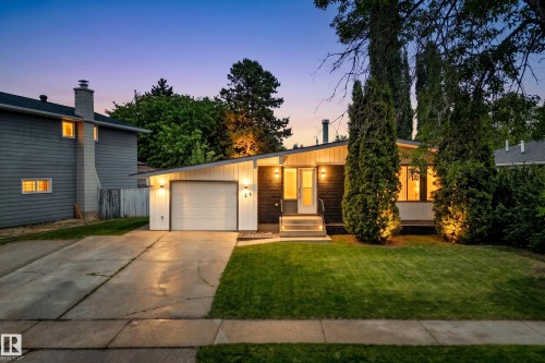 Front exterior featuring a single-car garage, concrete driveway, and a manicured lawn - 24 Addison Crescent, St. Albert, AB 