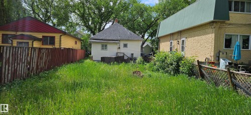 Rear exterior of a residence featuring white siding and a dark shingle roof - 12741 117 Street Nw, Edmonton, AB 