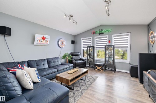 Living area featuring wood-finish flooring, vaulted ceilings, and track lighting - 363 Cy Becker Boulevard, Edmonton, AB - Indoor Photo Showing Living Room