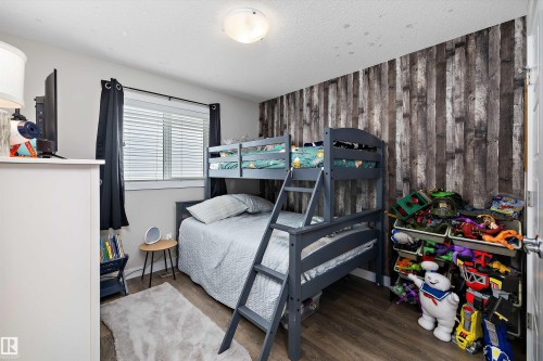 Interior room featuring wood-finish flooring and a distinctive wood panel accent wall - 363 Cy Becker Boulevard, Edmonton, AB - Indoor Photo Showing Bedroom