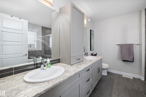 Bathroom featuring a double vanity with light-toned countertops, undermount sinks, and grey shaker-style cabinetry - 363 Cy Becker Boulevard, Edmonton, AB - Indoor Photo Showing Bathroom