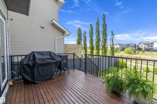 Expansive wood-finish deck featuring black metal railings and direct access to the interior via a sliding glass door - 363 Cy Becker Boulevard, Edmonton, AB - Outdoor With Deck Patio Veranda With Exterior