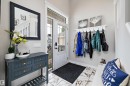 Foyer entrance featuring a glass-paneled entry door with transom window, white marble-style floor tiles, a built-in coat rack shelf, and staircase with white risers - 363 Cy Becker Boulevard, Edmonton, AB  - Indoor 
