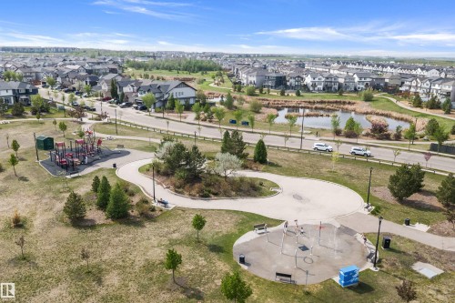 Expansive parkland featuring a playground, splash pad, walking paths, and a tranquil pond, surrounded by residential properties - 363 Cy Becker Boulevard, Edmonton, AB - Outdoor With View