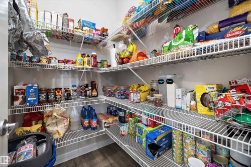 Walk-in pantry featuring white wire shelving, ample storage, and wood-finish flooring - 363 Cy Becker Boulevard, Edmonton, AB - Indoor With Storage