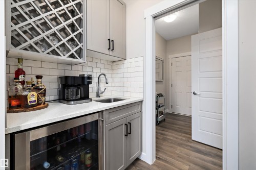 Wet bar featuring a wine rack, quartz countertop, and subway tile backsplash - 363 Cy Becker Boulevard, Edmonton, AB - Indoor Photo Showing Kitchen