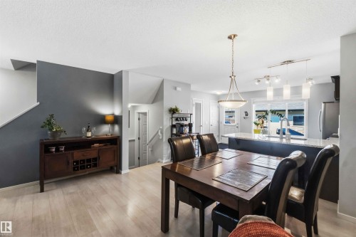 Open-concept dining and kitchen area featuring wood-finish flooring - 940 East Gate, Edmonton, AB 