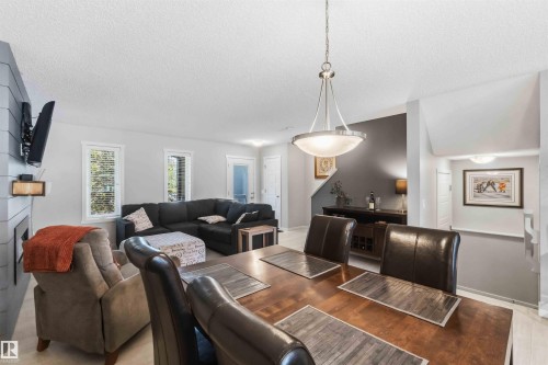 Dining area featuring a contemporary pendant light fixture over a wood-finish table - 940 East Gate, Edmonton, AB 