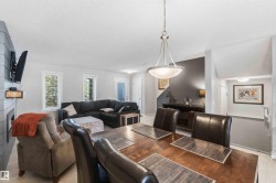 Dining area featuring a contemporary pendant light fixture over a wood-finish table - 