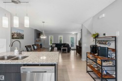 Kitchen island with a double basin stainless steel sink, granite-finish countertop, and stainless steel dishwasher - 