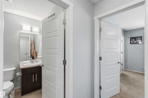 Bathroom vanity featuring a single sink, wood-finish cabinetry, and a countertop - 940 East Gate, Edmonton, AB 
