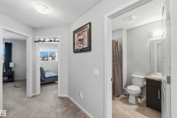 Hallway featuring light gray wall paint, textured ceiling, and flush-mount lighting - 